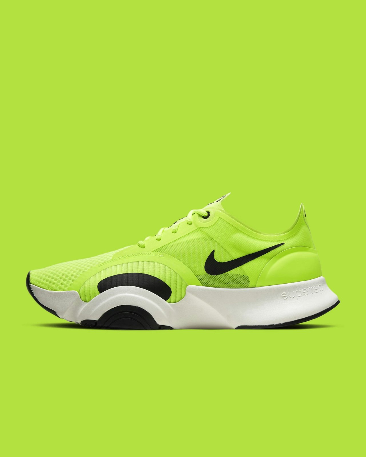 A volt-green training shoe with a white sole, photographed side on against a backdrop of the same volt green